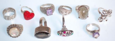 A group of ten silver rings to include a ring set with a faceted brown stone, a heart design ring