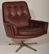 A vintage retro 20th Century button back swivel armchair, upholstered in an oxblood leatherette