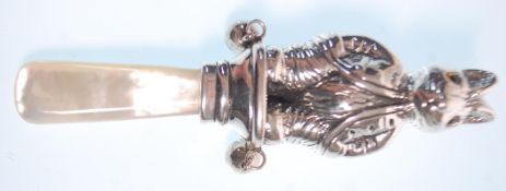 A stamped sterling silver rattle in the form of a rabbit having yellow glass eyes on a mother of