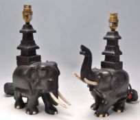 A pair of vintage 20th Century ebonised carved elephant table lamps with bone tusks and feet.
