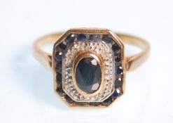 An Art Deco style ladies 9ct yellow gold ring set with a central oval blue cut stone having an