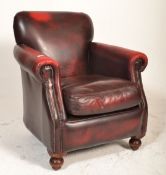 A 20th century Thomas Lloyd oxblood leather chesterfield armchair having bun feet with barrel arms