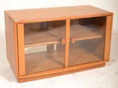 A good Ercol TV display unit stand of rectangular form having twin glazed doors with shaped wooden