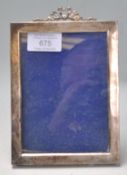 An early 20th Century silver hallmarked easel back photo frame of rectangular form with ribbon