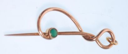 An early 20th Century Art Nouveau Murrle Bennett & Co gold pin of knot design set with a turquoise