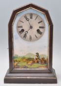 A late 19th / early 20th Century Junghans mantel clock having a wooden case with glazed door being