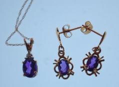A 9ct gold pendant necklace having a fine link chain with a pendant set with a oval cut purple stone