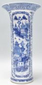 An early 20th Century Chinese blue and white vase of cylindrical form with a flared rim atop.