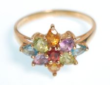 A hallmarked 9ct gold ladies dress ring set with a cluster of tear drop cut coloured stones. Bears