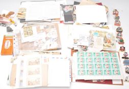 A collection of stamps and postcards to include an early 20th century postcard album of Paris