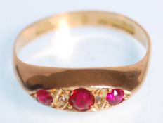 A hallmarked 18ct yellow gold gypsy ring set with three round faceted cut red stones with white