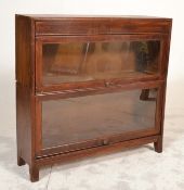 An early 20th century oak two tier sectional lawyers stacking bookcase cabinet with twin sections