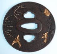 A 20th Century Japanese bronze tsuba of round form having raised bird and branch decoration with