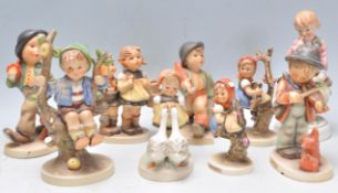 A collection of nine Goebel Hummel ceramic figurines to include apple tree boy, violinist, girl in a