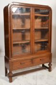 A 1930's Art Deco oak china display cabinet vitrine. Raised on cup and cover legs united by
