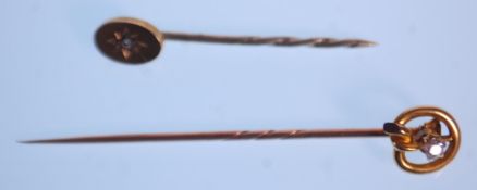 Two diamond set stick pins to include a knot design pin set with a round cut diamond of approx 70