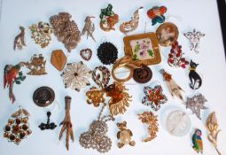 A collection of vintage brooches to include two scottish grouse claw brooches, a bird brooch with an