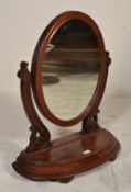A Victorian 19th century mahogany toilet swing mirror being raised on a shaped base with scrolled