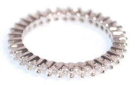 A white gold and diamond eternity ring set with round cut diamonds in prong settings. Weight 3.6g.