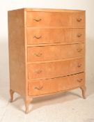 A 1930's Art Deco bow front walnut chest of drawers being raised on shaped legs with an upright bank