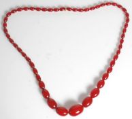 An early 20th Century necklace of graduating oval cherry bakelite beads. Measures 30 inches.