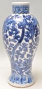 A 19th Century Chinese porcelain blue and white baluster vase being hand painted with scrolling