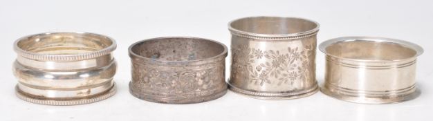 A group of four silver hallmarked napkin rings to include a napkin ring with gadrooned border (