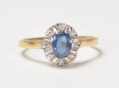 A hallmarked 18ct gold ladies dress ring set with a central blue sapphire with diamond accent stones