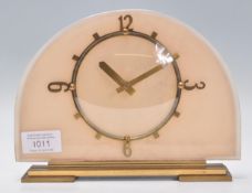 A 1930's Art Deco mantel clock having half moon glass face with peach backing, baton numerals with