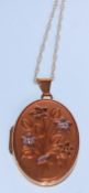 A 20th Century 9ct gold pendant necklace having a fine link chain with an oval locket decorated with