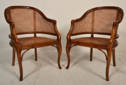 A pair of contemporary Antique style walnut smokers bow armchairs having bergere caned seat pads and