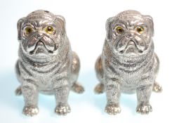 A pair of stamped 800 silver salt and pepper condiments in the form of pug dogs having yellow and