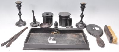 An early 20th Century ebonised wooden dressing table set consisting of mirror, tray, candlesticks,
