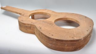 A vintage 20th Century wooden guitar mould maker of typical acoustic guitar form.  Measures 85 cm