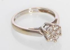A stamped 750 18ct white gold diamond cluster ring