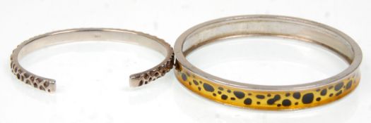 Two silver bangle bracelets to include a leopard printed decorated example hallmarked for London.