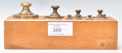 A set of 19th Century Victorian brass weights, graduating in size and weight set to a mahogany