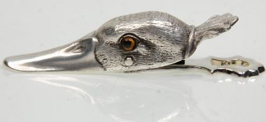A silver plated wall mounting paper clip in the form of a ducks had set with yellow glass eyes.