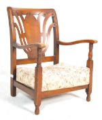 A 1930’s fireside armchair in beech wood having a sprung overstuffed seat with shaped back rest
