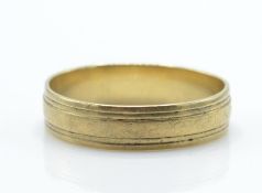 A 9ct gold band ring with reeded circumferential  design. Stamped 375. Total weight 3.3g / Size U.5.