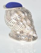A stamped 925 silver pincushion in the form of a conch shell, having a blue velvet cushion to the