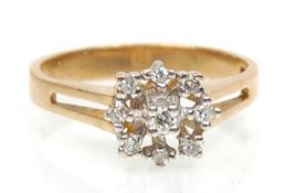 A hallmarked 9ct gold ring having a split band set with a cluster of round cut diamonds.