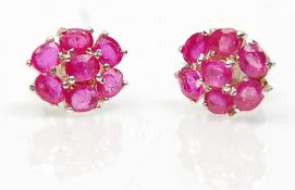 A pair of ladies stud earrings set with a cluster of oval cut rubies. Weight 2.7g. Measures 7mm.
