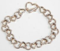 A 925 silver ladies hearts bracelet having heart shaped links and clasps. Stamped 925. Weighs 25.4g.