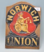 A vintage 20th Century tin plaque for Norwich Union having black and red ground with gilt