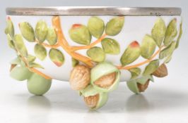 A 20th century Musterschutz porcelain fruit bowl with white metal rim, the bowl embellished with