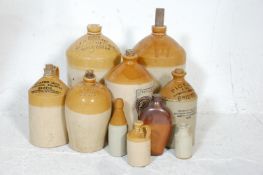 A collection of early 20th Century stoneware advertising flagons of various shapes and sizes in