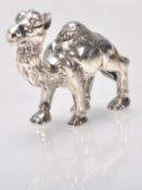 A stamped sterling silver figurine in the form of a camel with embossed detailing. Weight 16.8g.