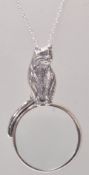 A stamped 925 silver pendant necklace having a magnifying glass pendant having a cat handle with a