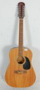 A 20th Century Freshman twelve string guitar having a black scratch board with inlaid markers to the